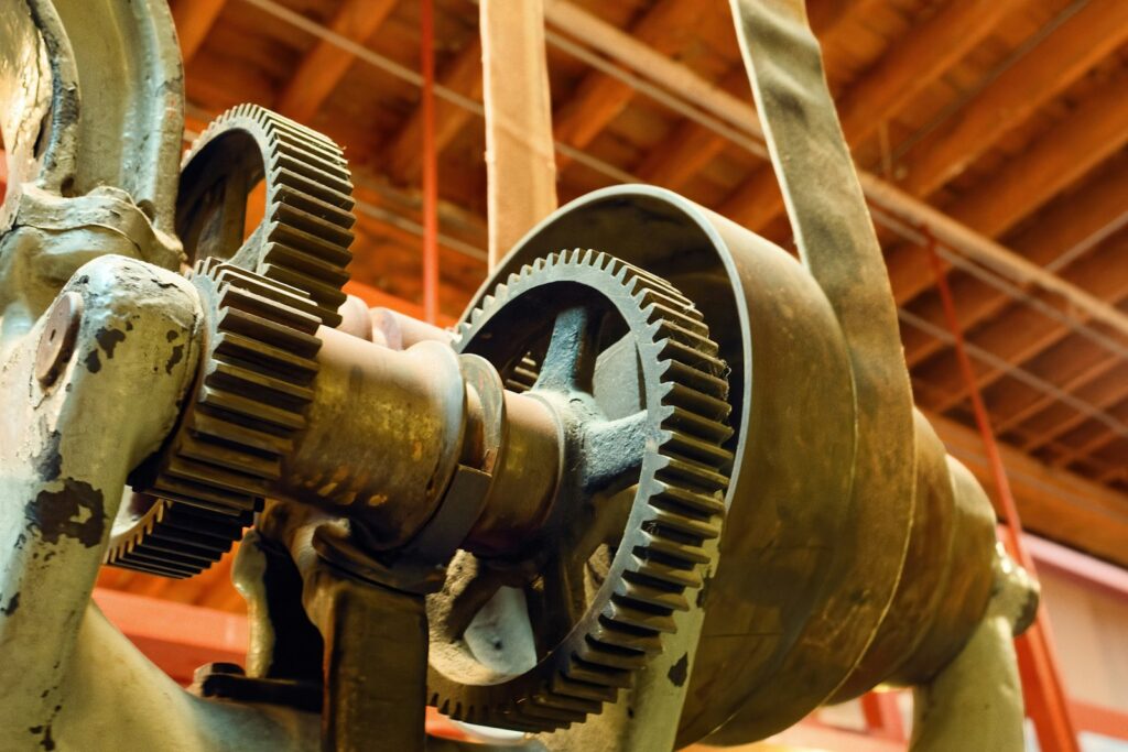 Close-up of industrial gears and machinery, representing the mechanical wear a bronze bushing is designed to absorb