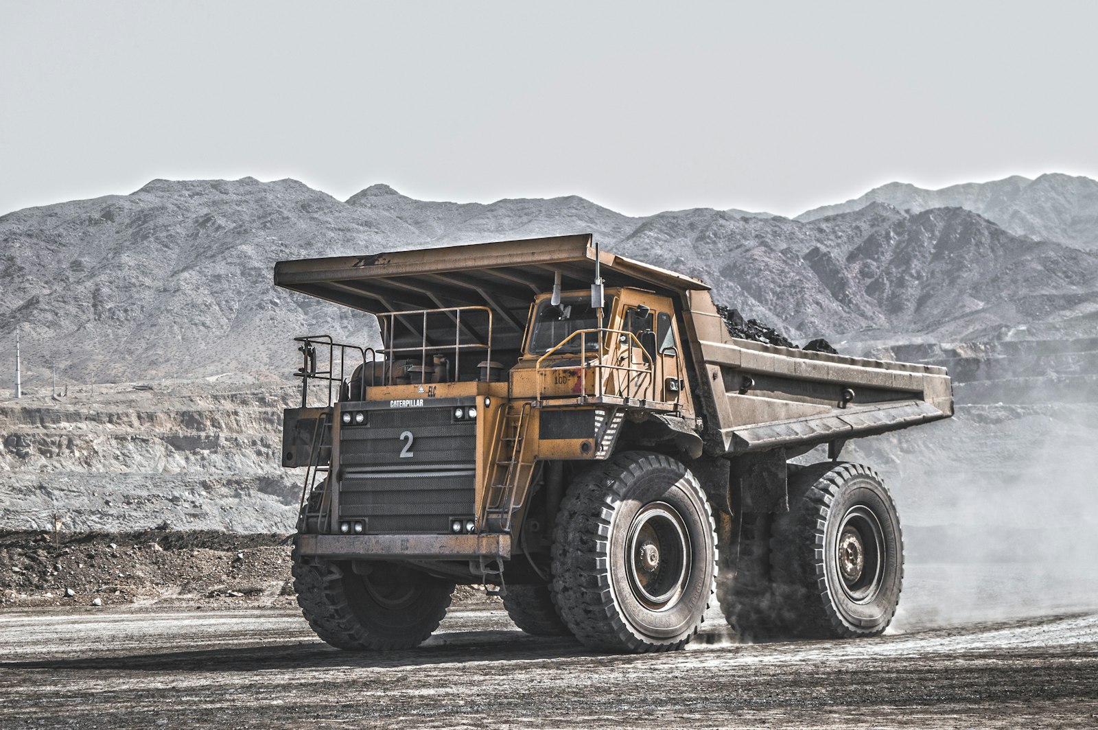 Haul truck moving ore at a mining site, feeding material toward the mill