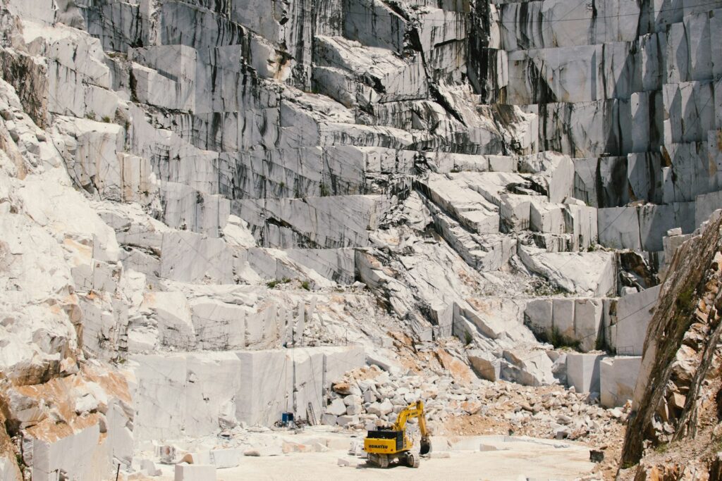 Quarry excavator loading crushed rock feed for a jaw crusher